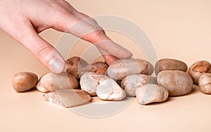 Tactility and sensory feelings concept. Hand touching stones closeup