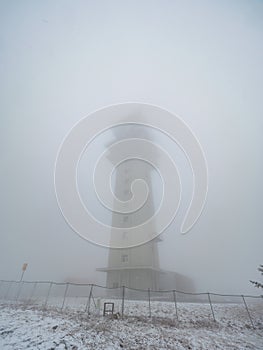 Tadiocommunication tower in fog. Klinovec Mountain