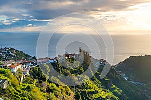 Taditional Madeira houses in Funchal behind a banana plantation and ocean sunset