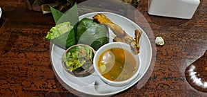 Taditional meal: tamarin soup, rice cover banana leafe, fried chicken