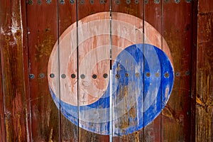 Taegeuk symbol painted on the wooden door with the flowers made of metal decoration photo
