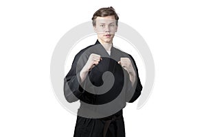 Taekwando.A teenager in a black kimano who is engaged in taekwando