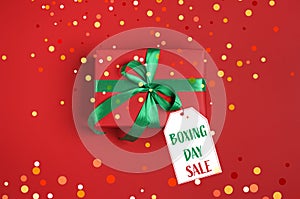 Tag wth text Boxing Day Sale attached to gift on red background