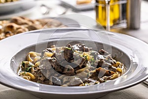 Tagliatelle con salsiccia e porcini, Italian pasta with sausage and summer cep mushroom photo