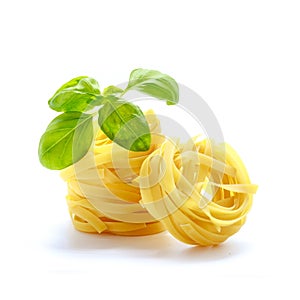 Tagliatelle italian pasta with basil isolated on white background.