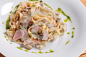 Tagliatelle pasta with ham, mushrooms and yolk. Selective focus