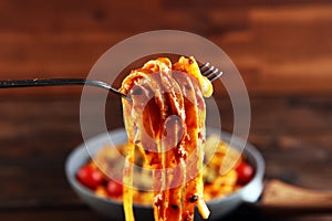 Tagliatelle pasta with tomato sauce parmesan basil on rustic background