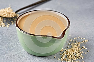 Tahini paste in bowl with sesame seeds. Close up