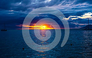 Tahiti sunset revealed behind a dramatic cloudscape, with the tranquil waters of an ocean