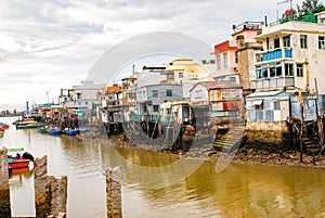 Tai O fishing village, Lantau Island. Primitive sheet metal houses stand on stilts to which fishing boats are moored. A popular