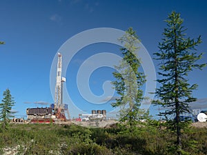 Taiga landscape with a drilling rig in an oil and gas field