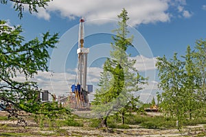 Taiga landscape with a drilling rig in an oil and gas field