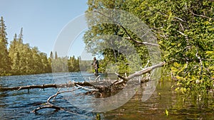 Taiga river nature of the Russian North. Flyfisherman using flyfishing rod in a river.