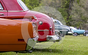 Tail end of several classic cars