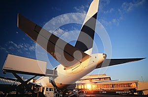 Tail fin of airplane at airport sunset