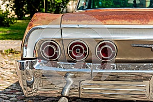 Tail lights of a weathered classic american car from the sixties