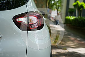 Tail lights of the white car parked on the street, back view, close-up