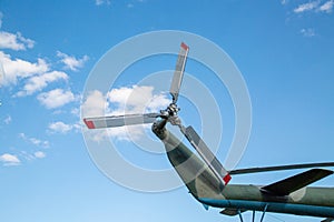 The tail rotor of the helicopter is gray silver color against the blue sky on a clear sunny day