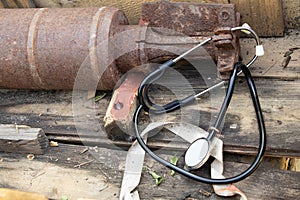 A tail of rusty ammunition and a stethoscope lie in a wooden box with ammunition, military medicine