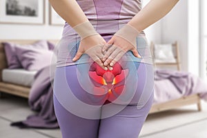 Tailbone pain, coccyx fracture, woman suffering from coccygodynia at home