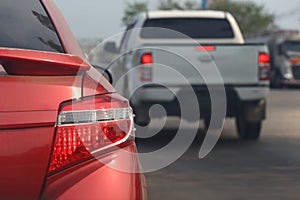 The taillight of a braking car on the road and a blurred image behind another car