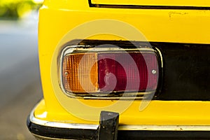 Taillight details of an antique car in yellow