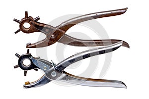 Tailor accessories. Close-up of a antique adjustable steel punch pliers and a modern hole punch tool isolated. Clipping path.