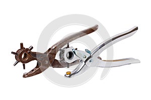 Tailor accessories. Close-up of a antique adjustable steel punch pliers and a modern hole punch tool isolated. Clipping path.