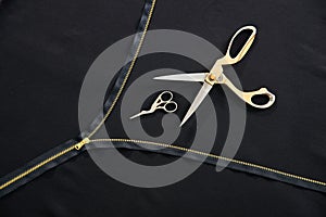 Tailor background with open golden zipper and two scissors in atelier studio