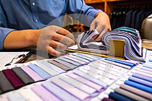 tailor choosing a fabric in swatch for his customer