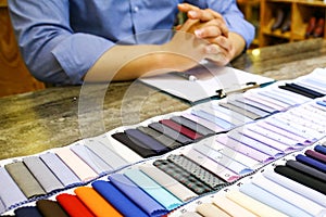 tailor choosing a fabric in swatch for his customer