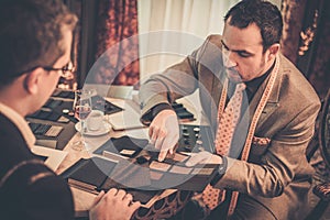 Tailor and client choosing materials for suit