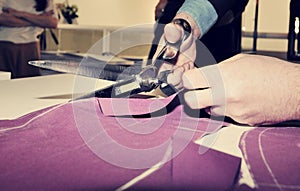 Tailor cutting fabric for bespoke suit photo