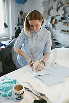 Tailor Cutting Fabric With Scissors In Atelier photo