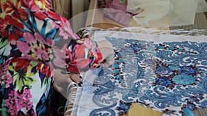 Tailor.Hands notch tailor tailor`s scissors cloth. Female tailor stitching material at workplace. Preparing fabric for