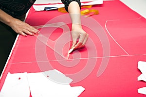 Tailor hands working with pink fabric