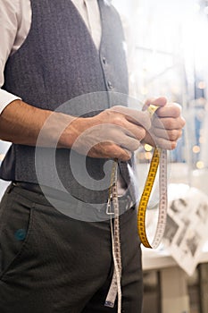 Tailor Holding Measuring Tape Close Up