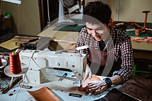 tailor man using sewing machine with table lamp