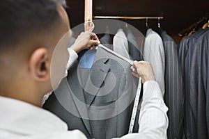 Tailor measuring shoulder of the suit