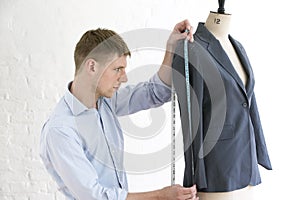 Tailor Measuring Suit On Mannequin In Studio