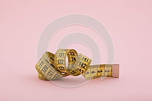 Tailor measuring tape on pink background