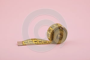 Tailor measuring tape on pink background