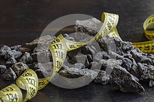 A tailor meter lies on a pile of rubble