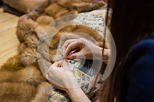 Tailor repairing fur coat