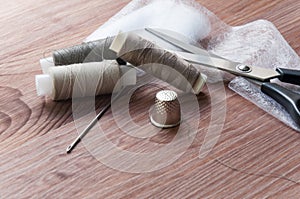 The tailor`s desk. Old sewing wooden drums or skeins on an old wooden worktable with scissors.