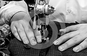 Tailor`s hands close-up sew clothes on an old retro sewing machine. Tools for a tailor, fashion designer or seamstress