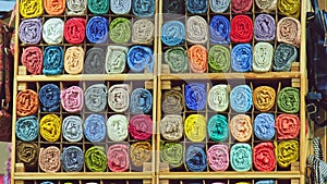 tailor store colorful textile texture rolls of fabric on shelves background