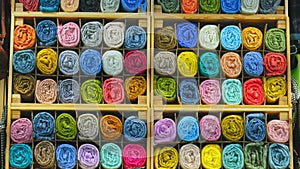 tailor store colorful textile texture rolls of fabric on shelves background