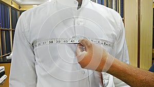 Tailor taking measurements of man chest photo