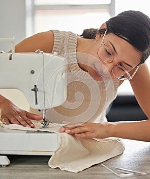 Tailor, woman and sewing machine in apartment for small business, fashion design and pride. Female seamstress, smile and